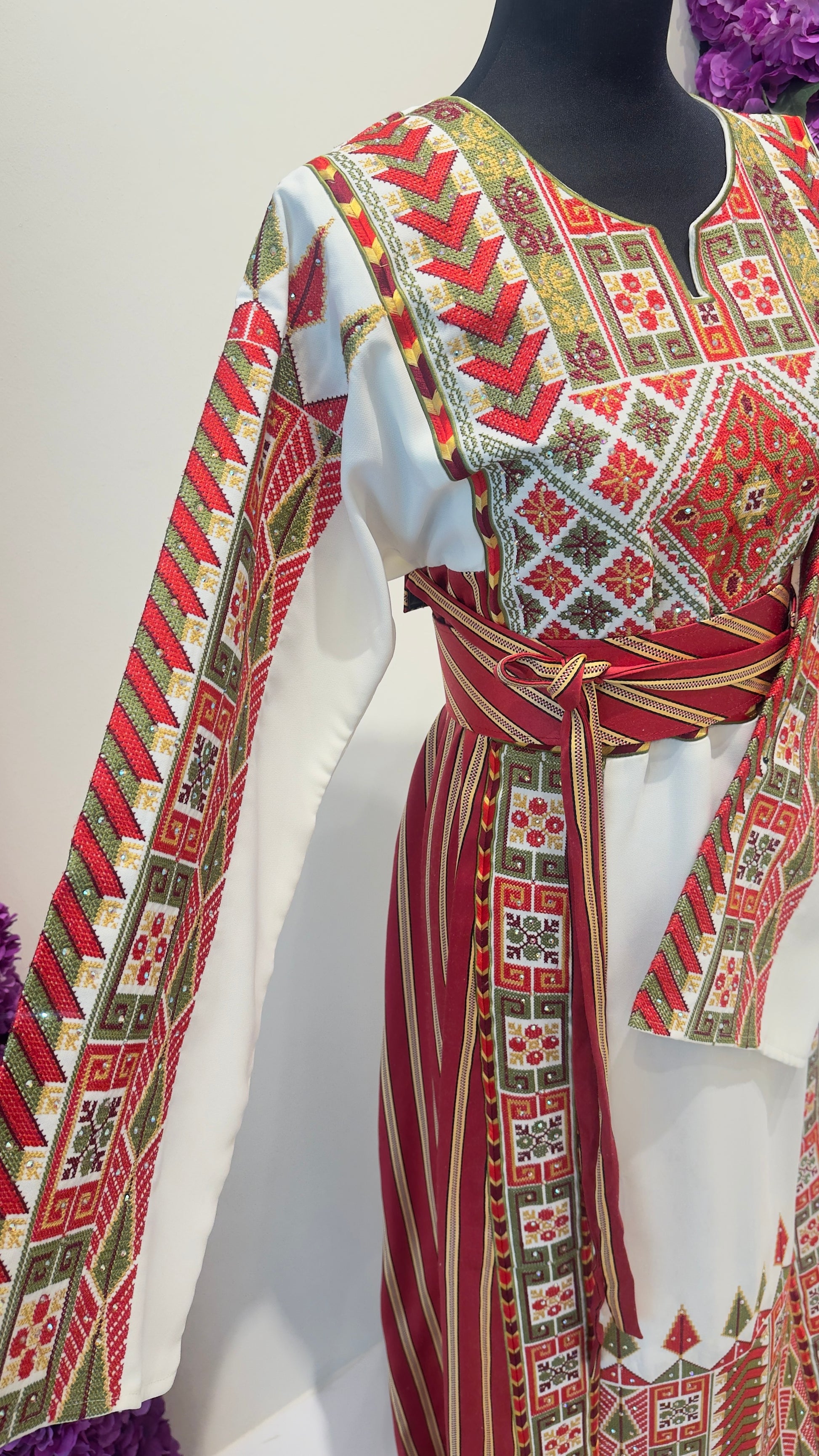 Traditional patterned garment on a mannequin against a white background