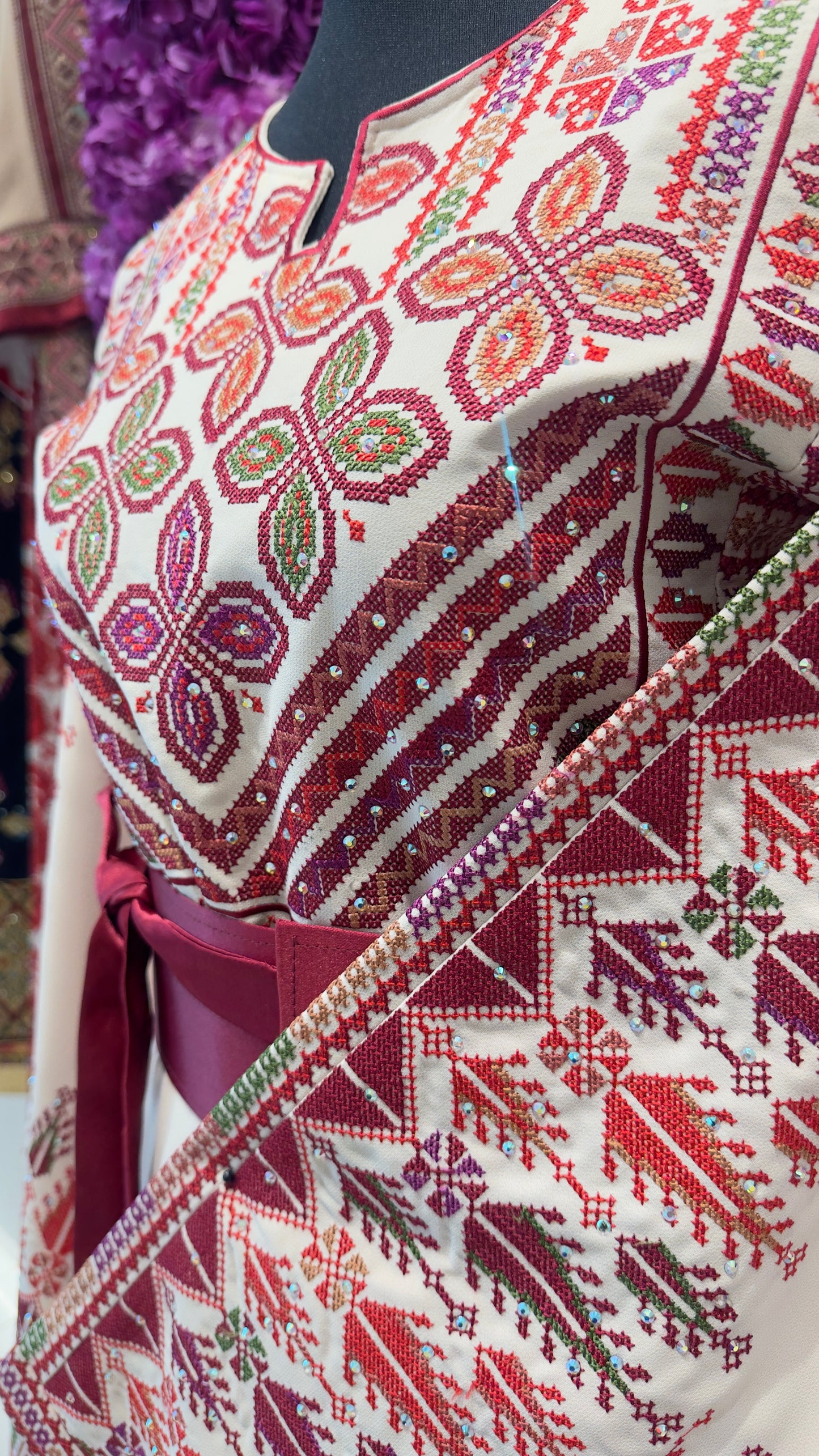 Traditional embroidered garment with intricate patterns on a mannequin.