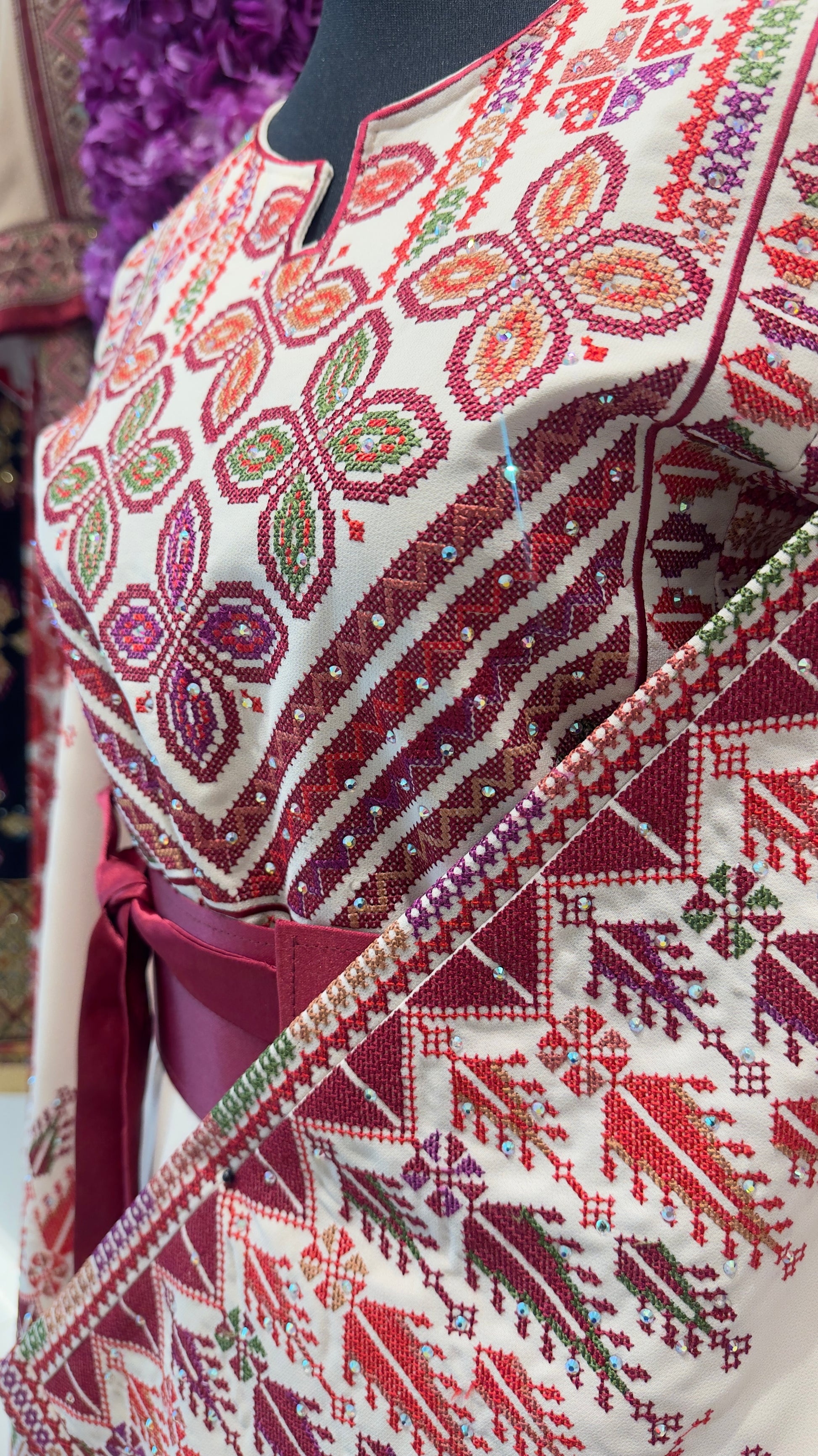 Traditional embroidered garment with intricate patterns on a mannequin.
