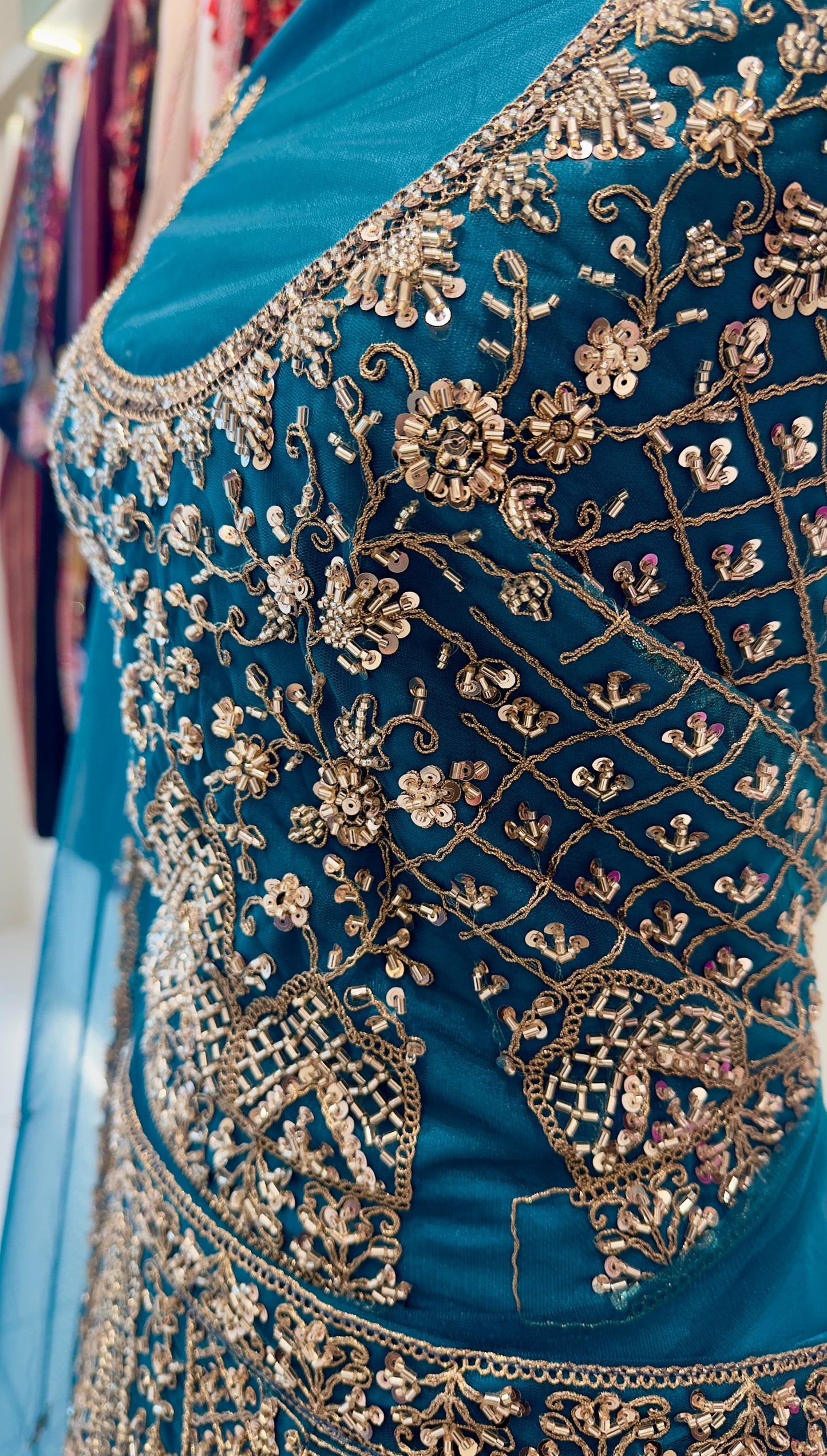 Close-up of a blue garment with intricate gold embroidery