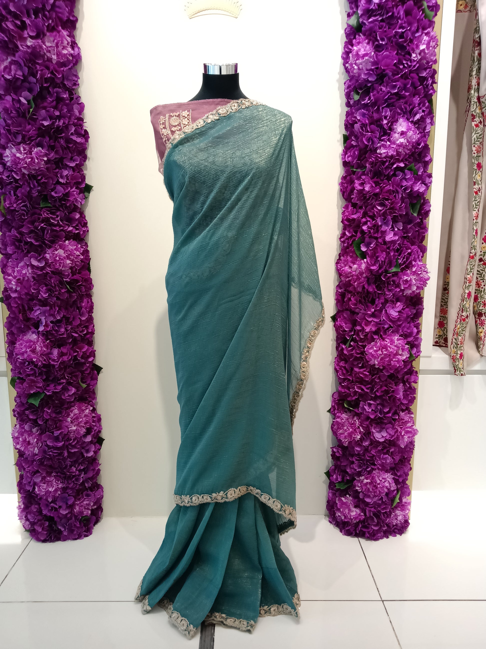 Shop elegant teal ready to wear saree in Qatar. Pre stitched with perfect pleats, soft shimmer fabric & gold border. Ideal for parties & events.