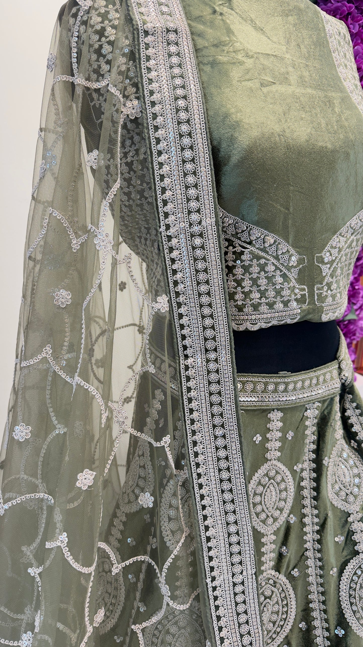 Traditional green saree with silver embroidery on a white background