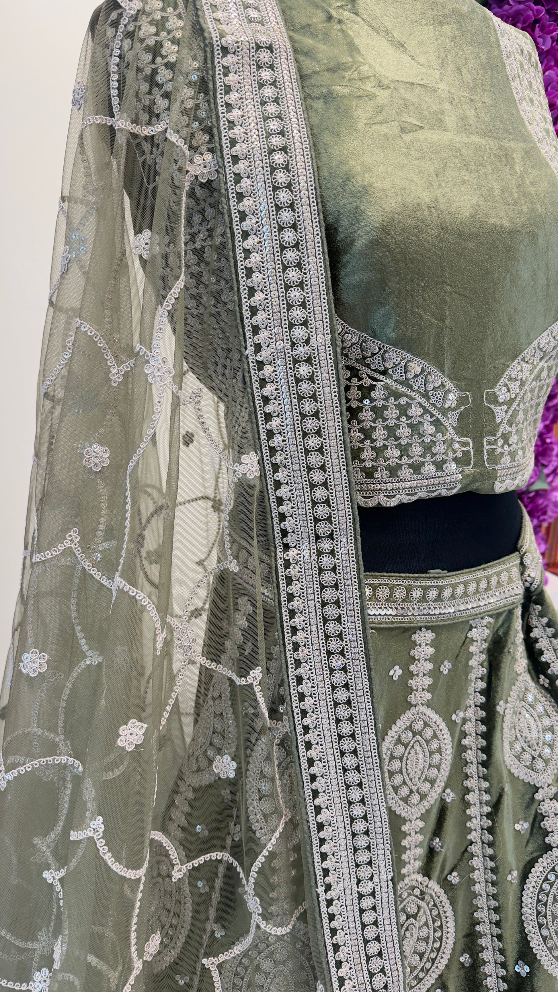 Traditional green saree with silver embroidery on a white background