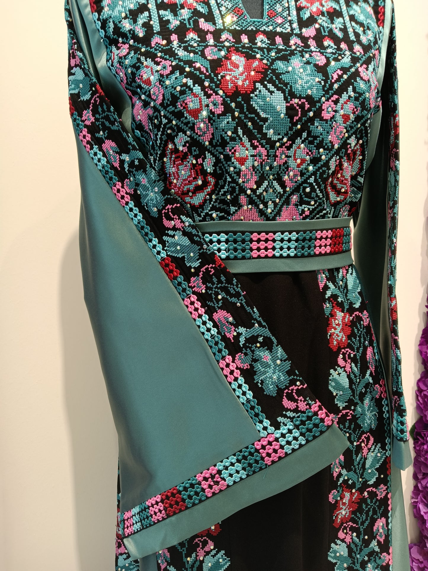 traditional Arabic dress women with teal floral embroidery.