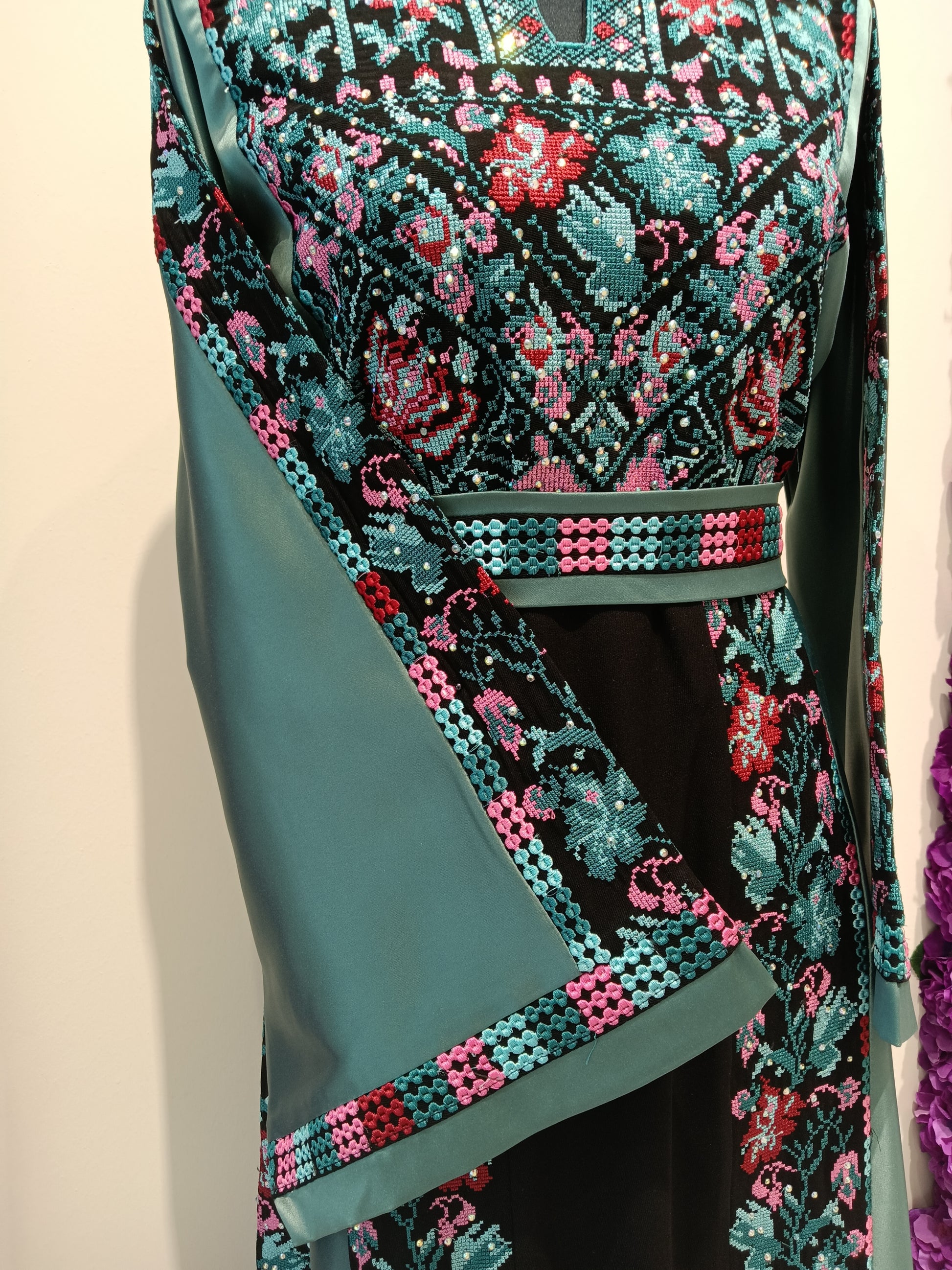 traditional Arabic dress women with teal floral embroidery.