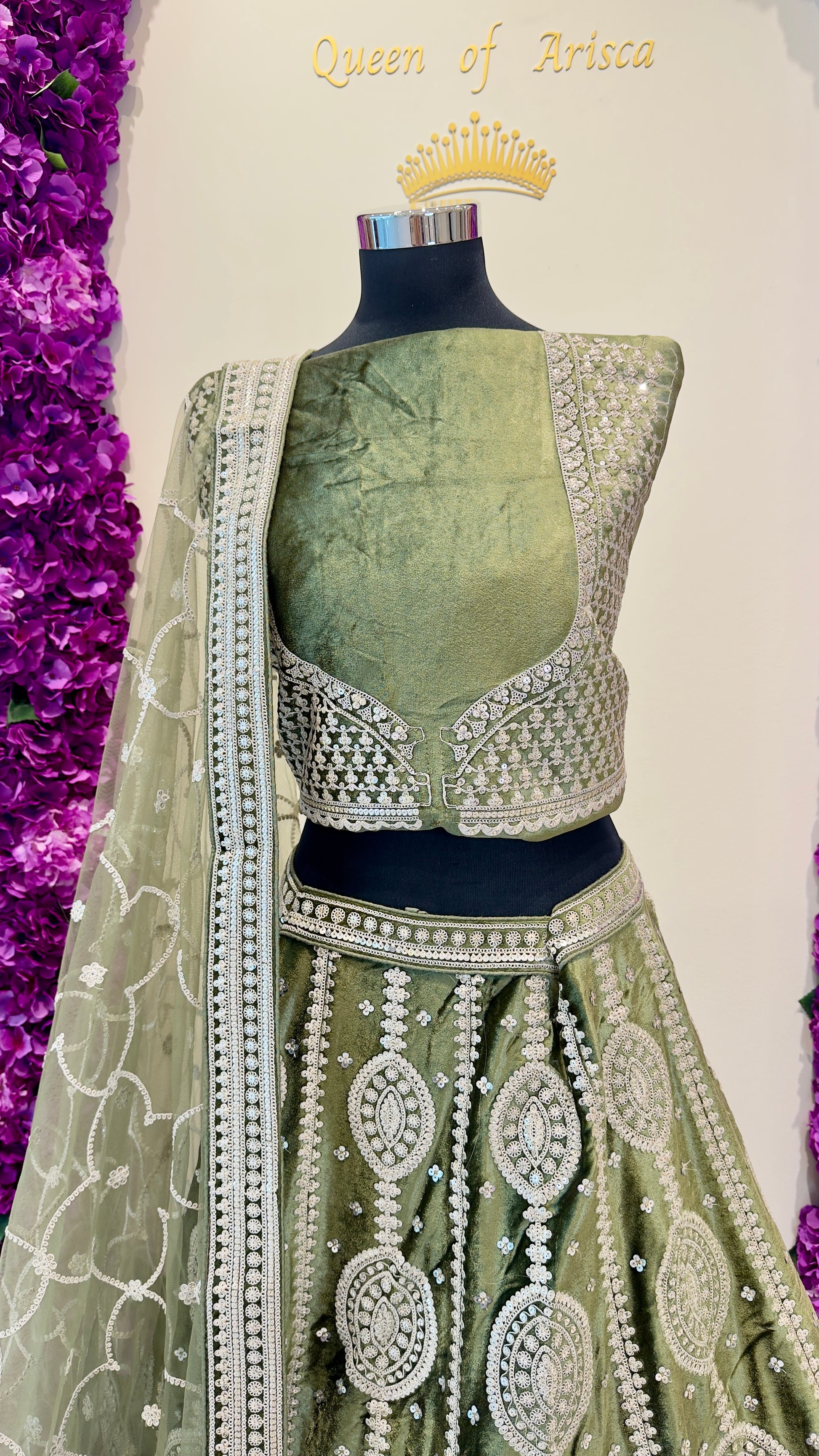 Green embroidered traditional outfit with a purple floral background