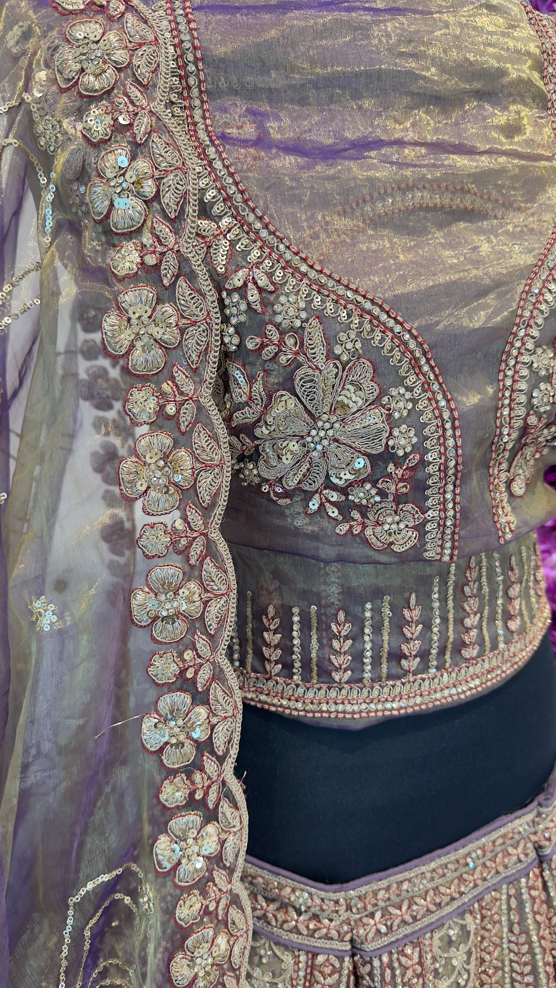 Close-up of a intricately designed blouse with floral patterns and embellishments.